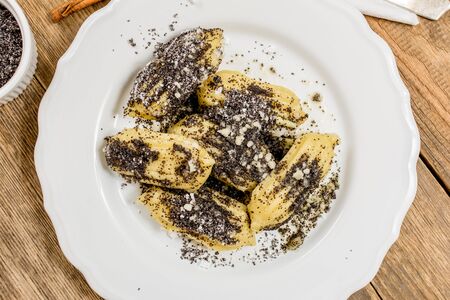 Pasta cnocchi with poppy sugar and butter on wood tableの写真素材