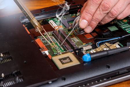 Man fixing damaged memory computer or laptop with soldering iron