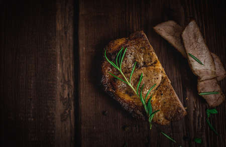 Grilled pork neck steak with rosemary on wood tableの写真素材