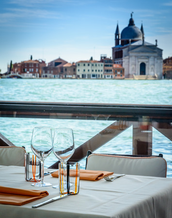 Dining tables in outdoor restaurant and Church of the Santissimo Redentore  in beautiful city Veniceの写真素材