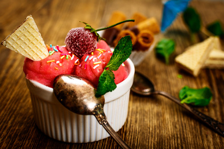 Fresh strawberry ice cream with waffle on wood table