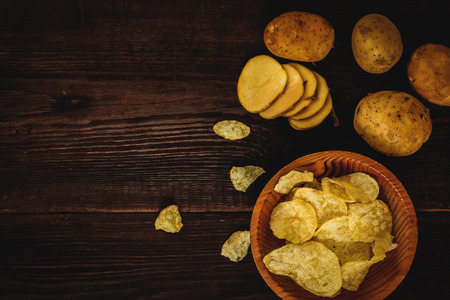 Salty potato chips snack  on wood table top viewの写真素材