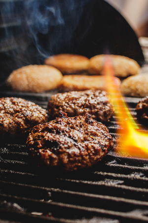 Hot fresh beef hamburger on grill and breadの写真素材