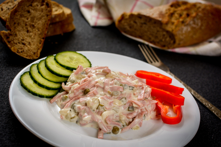 Mayonnaise mixed salad with vegetables and sausage nad baquetteの写真素材