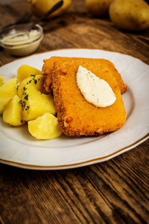 fried cheese with potato and dip on wood tableの写真素材