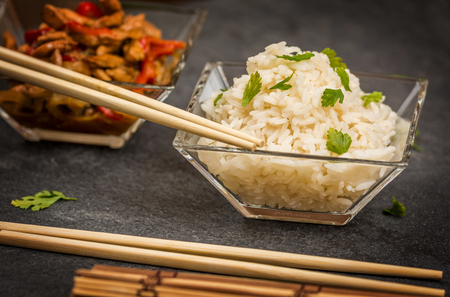 Asian chicken with vegetables and rice in glass plateの写真素材