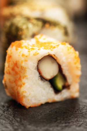 Traditional japanese sushi rolls  uramaki and chopsticks on stone deskの写真素材