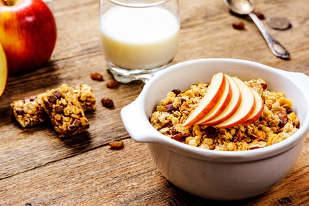 Healthy breakfast. Muesli with apple,raisins, muesli bar and milkの写真素材