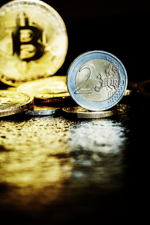 Virtual currency Bitcoin and Euro coin on dark tableの写真素材