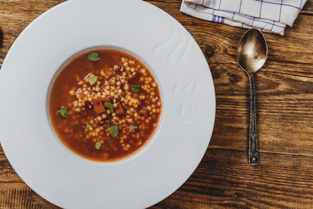 Tomato soup with egg barley on wood table