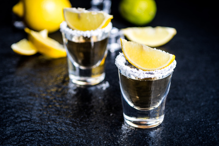 Mexican traditional  Tequila with lemon,salt and ice cube on dark stone table tableの写真素材