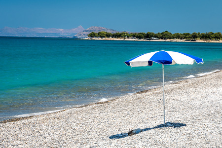 Ocean beach and sunshade on the Crete in sunny dayの写真素材