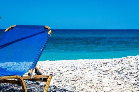 Ocean beach and sunbeds on the Crete in sunny day