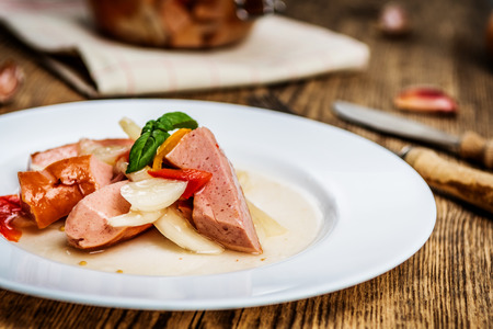Czech pickled sausages with onion, pepper, vinegar on wood table. Czech name utopenci or utopenecの写真素材
