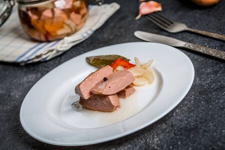Czech pickled sausages with onion, pepper, vinegar on dark stone  table. Czech name utopenci or utopenecの写真素材