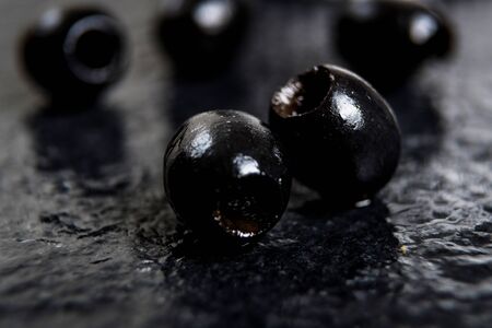 Black olives  on wet black stone tableの写真素材