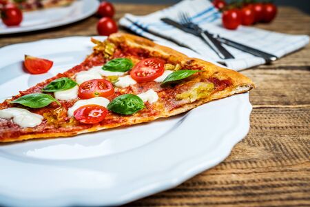 Traditional italian food pizza with mozzarella, tomato and salami on wood tableの写真素材