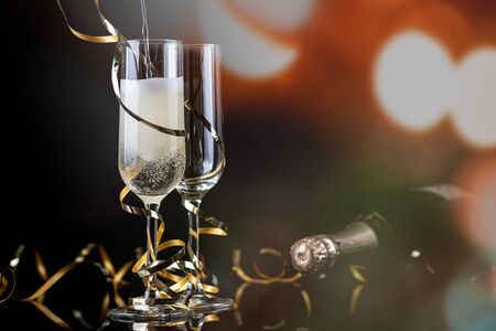 champagne glasses with golden ribbon and  sparkles on black background - new year celebrationの写真素材