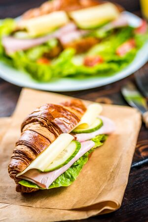 French breakfast croissant with ham, cheese and lettuce on wood tableの写真素材