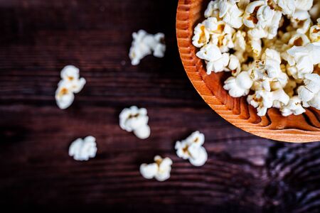 Popcorn in wood dish or bowl on dark wood tableの写真素材