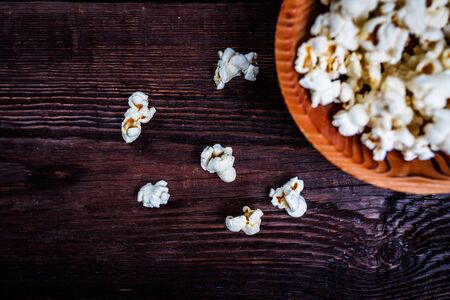 Popcorn in wood dish or bowl on dark wood tableの写真素材