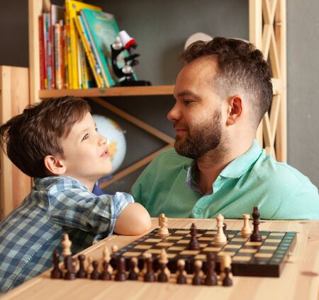 Father and son child playing chess at home, paternity leaveの写真素材