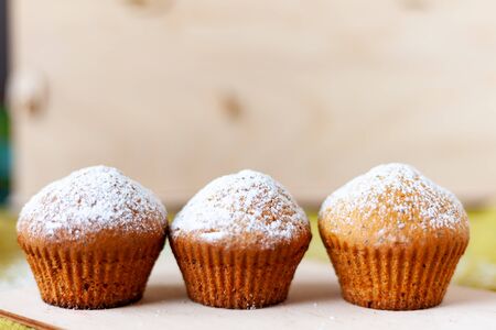 delicious muffin in icing sugar on a tableの写真素材