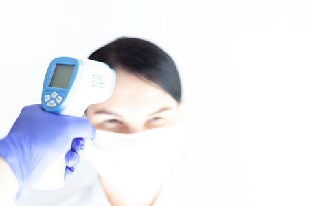Doctor check woman body temperature using infrared thermometer for virus symptom
