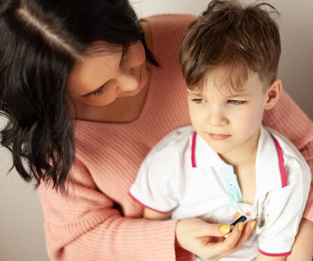 mom measures the temperature of the child, the boy got the virus, symptoms of the virusの写真素材