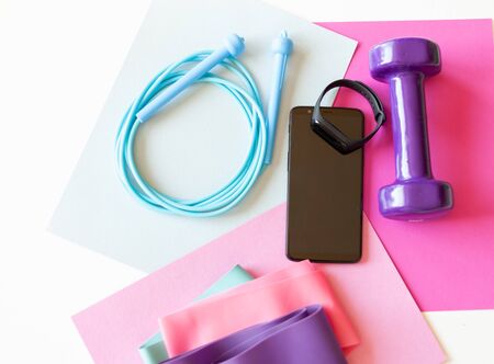 smartphone and fitness bracelet, dumbbell jump rope and elastic bands for fitness, sports equipment, healthy lifestyle concept, online fitnessの写真素材