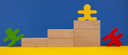 figures of men green yellow red climb the stairs and fall down, the concept of the social ladder, career growthの写真素材