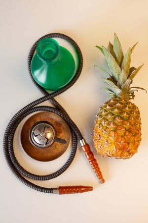 pineapple fruit and pieces of hookah on a white tableの写真素材