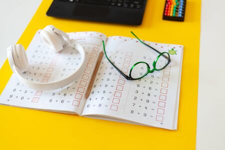 laptop, glasses, headphones, a notebook lie on the desk, desk of a modern schoolboy, concept of...