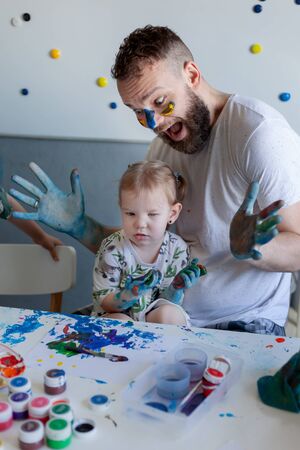 dad and daughter paint at home stained with paintの写真素材