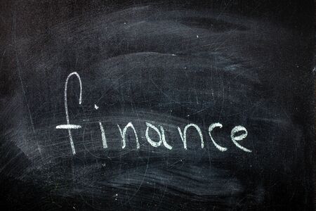 word finance written in chalk on a blackboardの写真素材