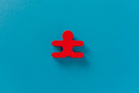 red figurine of a man against the background of classic blue stands aside from the crowd of people. Asociality, sociopathy. Rejected from society, lonely. Development of leadership and social qualities. Infected, fear and misunderstanding.の写真素材