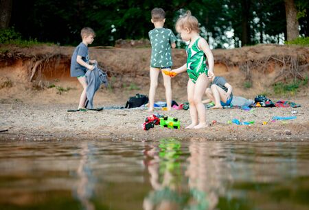 Happy child playing with sand at the beach in summerの写真素材
