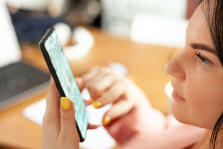 young woman works from home using her smartphone, concept of remote work, work on the Internet