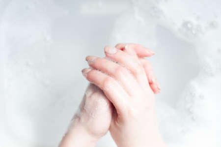 Man washing soapy hands in bathroomwoman washes her hands over water with foam, hygiene rules and...