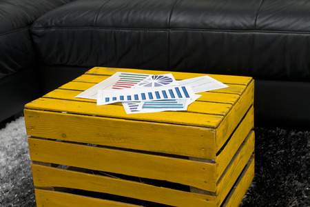 Yellow coffee table with financial graphs and chartsの写真素材