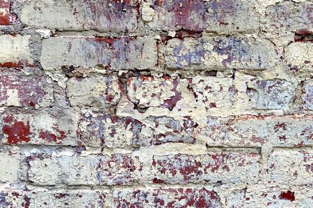 an old brick wall with white faded paintの写真素材