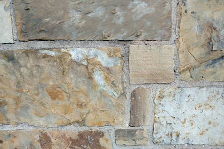 a colorful sand tan brown block cut slate rock wall close-up