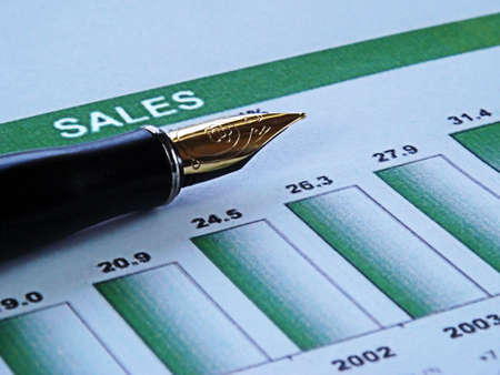 close-up of a pen on top of a financial graph showing sales growth
