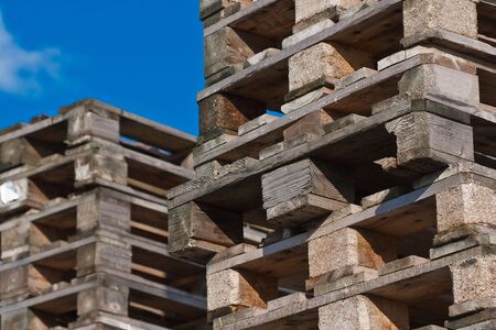 Two piles of euro pallets with clear blue sky in background