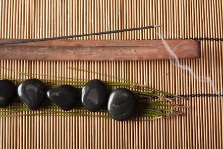 burning incense and volcanic hot-stones placed on bamboo matの写真素材