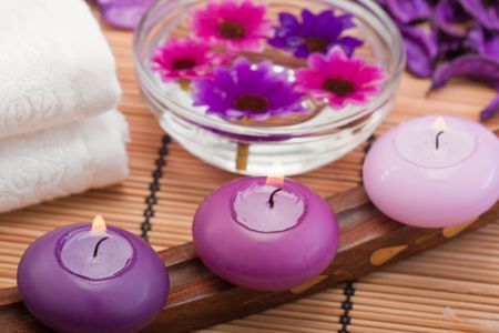 three purple toned candles and flowers in spa setting (2)の写真素材