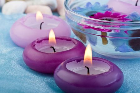 purple toned candles and flowers on baby blue silk (2)の写真素材