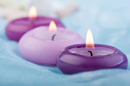 composition of three purple toned candles on baby blue silk (2)の写真素材