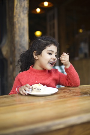 Girl eating sweet pieの写真素材