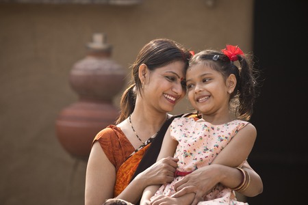 portrait of loving Indian mother and daughter at villageの写真素材
